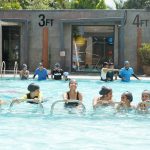 Adults exercising together in a warm indoor pool during a hydrotherapy class